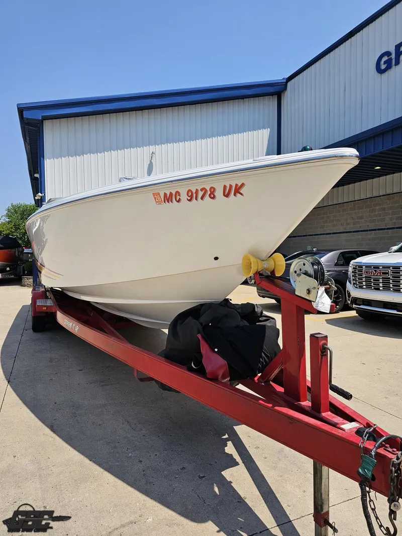 Slide: The Image of 2005 Baja 33 Outlaw boat on red trailer, parked outside a building. - 16
