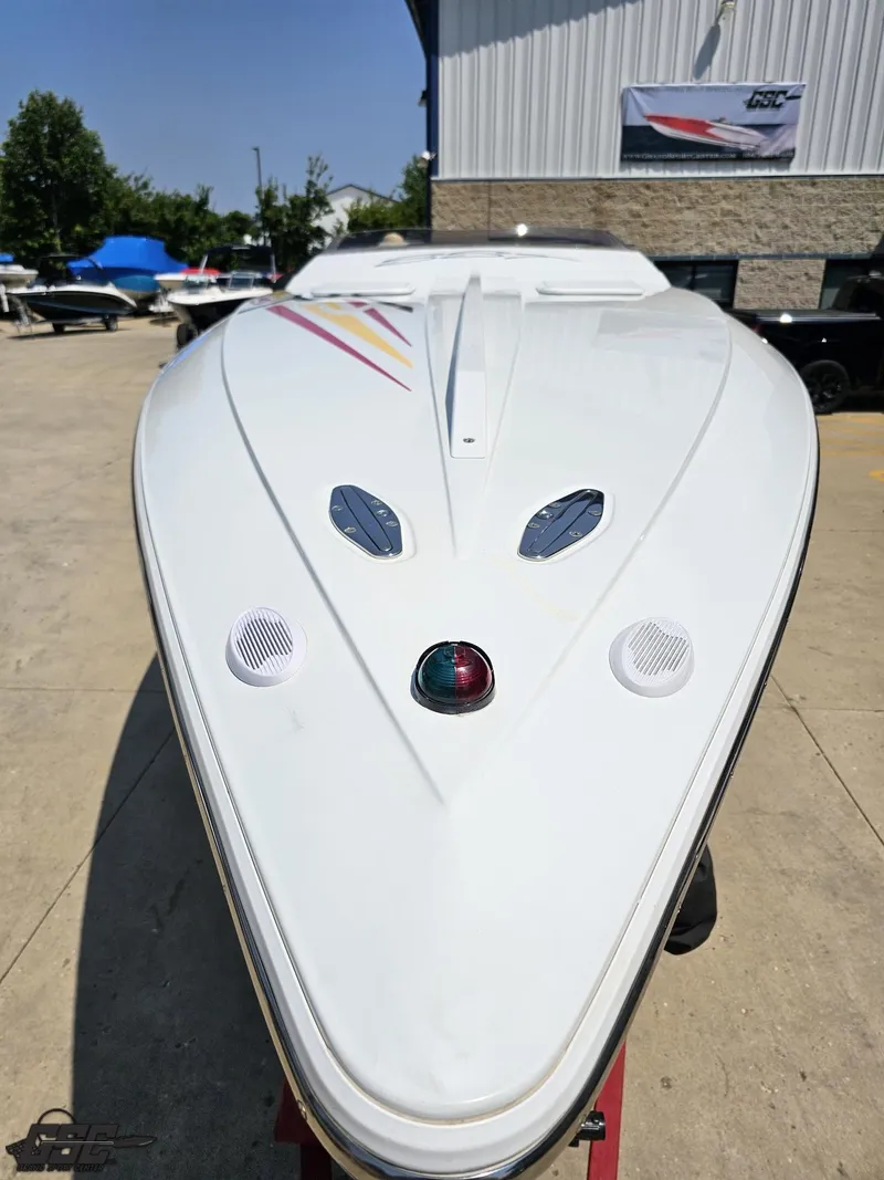 Slide: The Image of 2005 Baja 33 Outlaw boat, white hull, parked outdoors near a building. - 18
