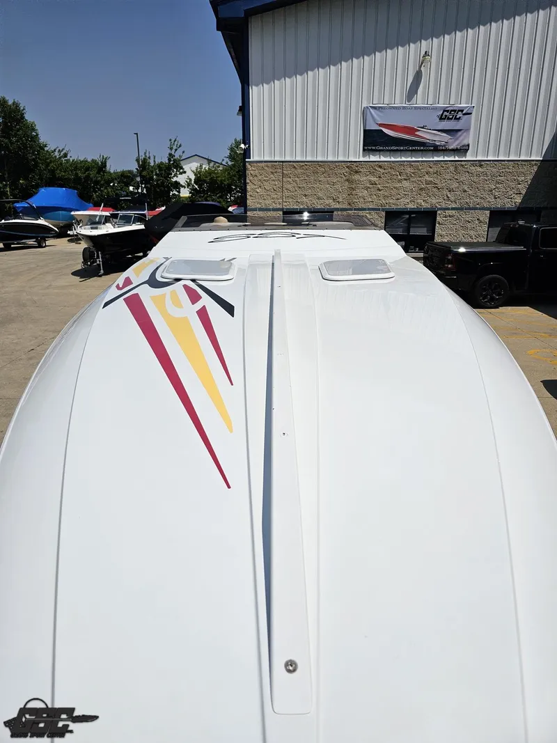 Slide: The Image of 2005 Baja 33 Outlaw boat with colorful graphics, parked outdoors near a building. - 19