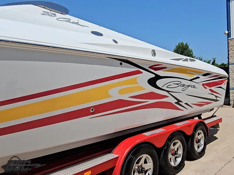 Slide: The Image of 2005 Baja 33 Outlaw speedboat with vibrant graphics on a red trailer. - 22