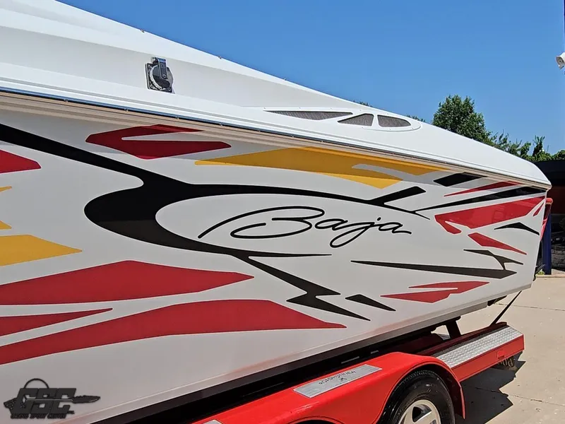 Slide: The Image of 2005 Baja 33 Outlaw boat with vibrant graphics on a red trailer. - 23