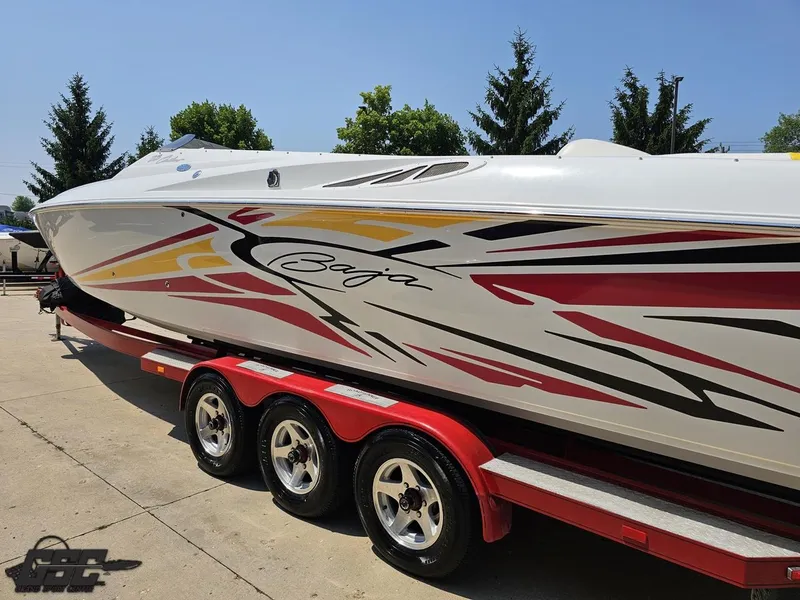 Slide: The Image of 2005 Baja 33 Outlaw boat with vibrant graphics on a red trailer. - 29