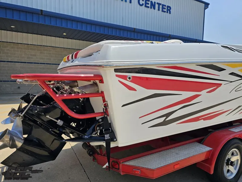 Slide: The Image of 2005 Baja 33 Outlaw boat with vibrant graphics on a trailer near a service center. - 35