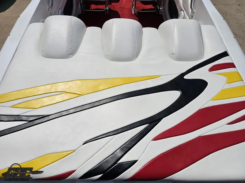 Slide: The Image of 2005 Baja 33 Outlaw boat interior with vibrant red, yellow, and black upholstery design. - 40