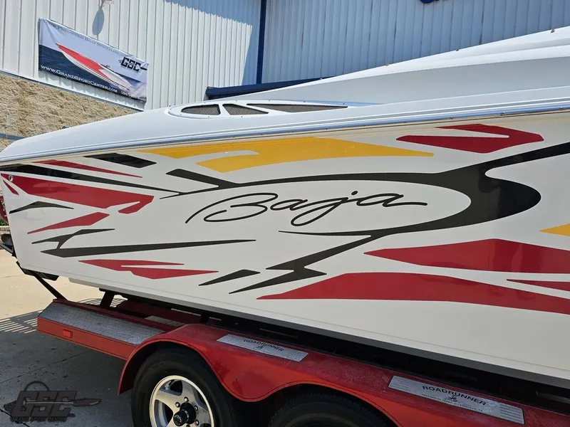 Slide: The Image of 2005 Baja 33 Outlaw boat with vibrant graphics on a trailer. - 6