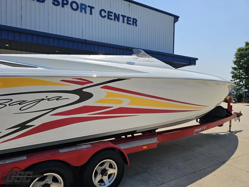 Slide: The Image of 2005 Baja 33 Outlaw boat on trailer at sports center, vibrant graphics. - 9