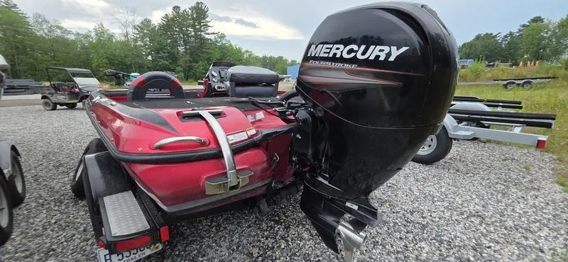 Slide: The Image of Red Nitro Z7 boat with Mercury outboard motor, parked on gravel, surrounded by trees. - 2