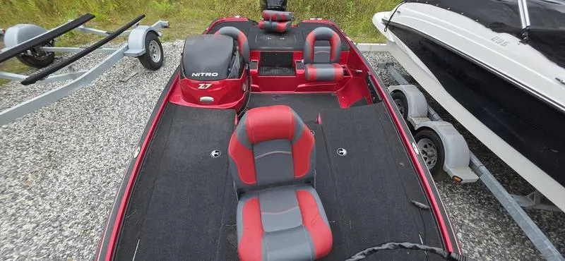 Slide: The Image of Red and gray 2015 Nitro Z7 boat with seating, parked on gravel. - 5