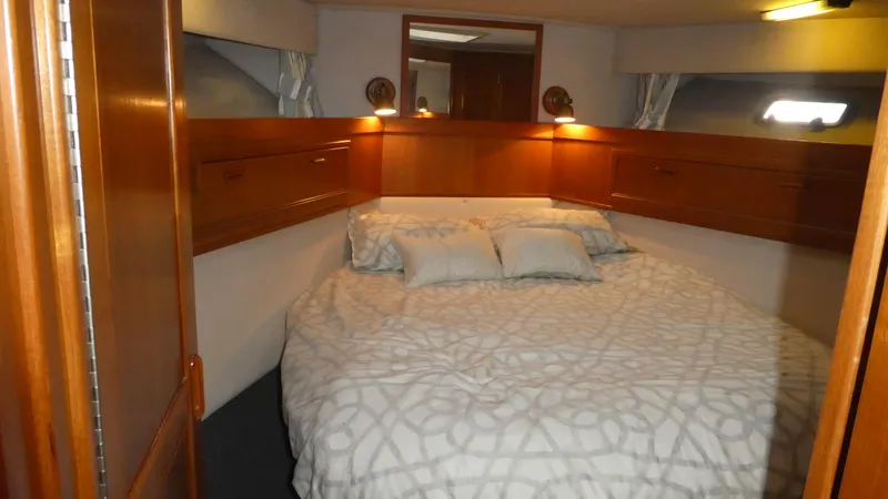 Slide: The Image of Cozy bedroom in 1995 Riviera Convertible yacht with wooden cabinets and soft lighting. - 10
