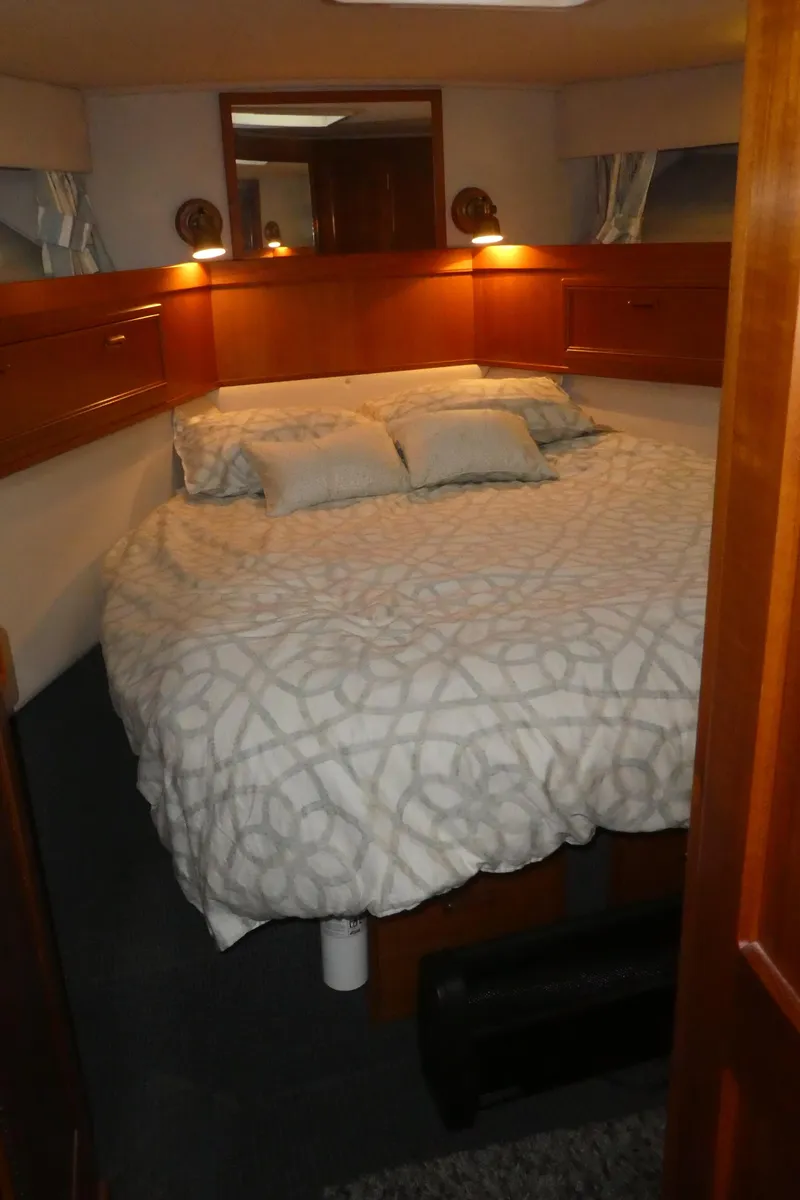 Slide: The Image of Cozy bedroom in 1995 Riviera Convertible yacht with elegant bedding and warm lighting. - 12