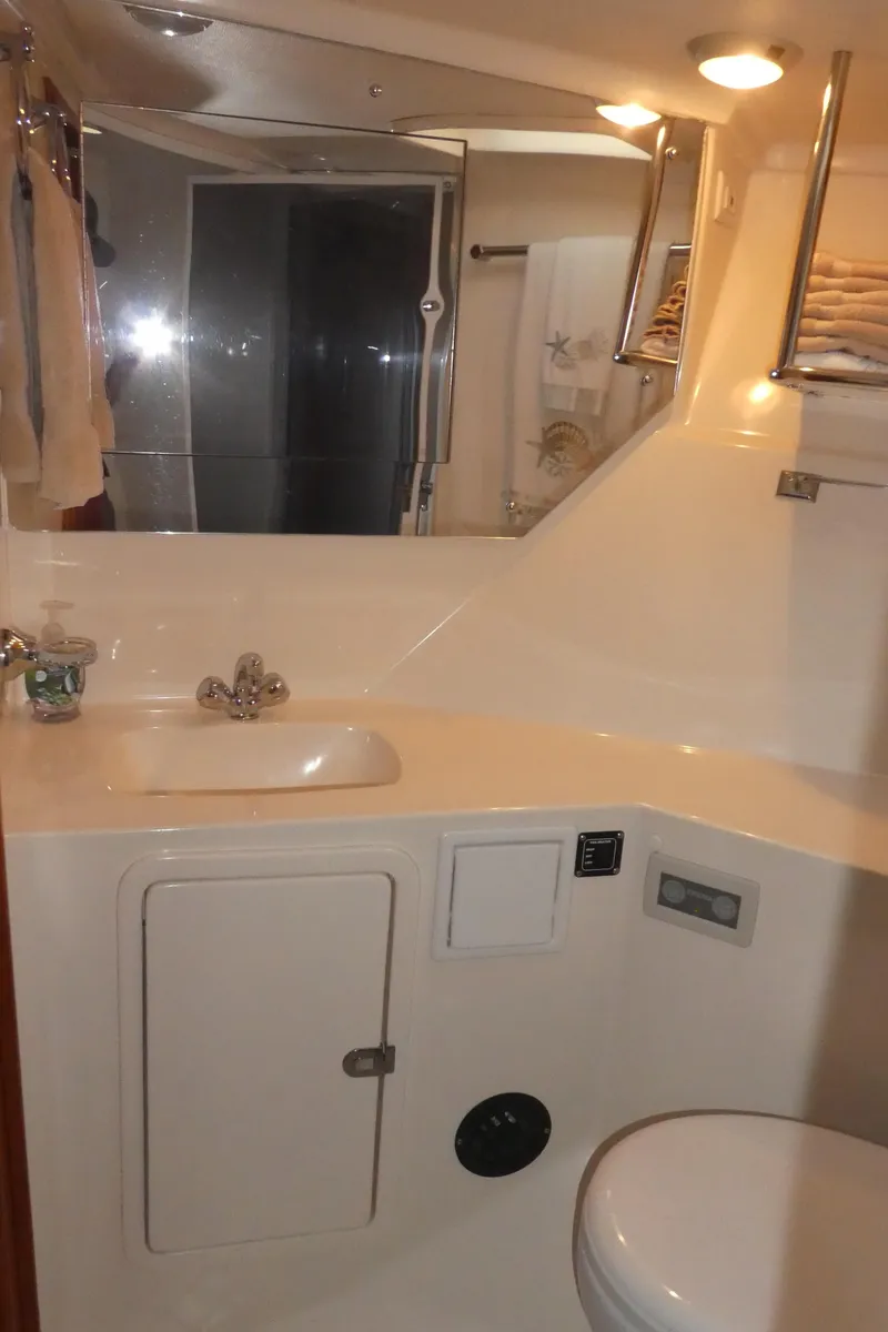 Slide: The Image of 1995 Riviera Convertible yacht bathroom with sink, mirror, and storage cabinet. - 15
