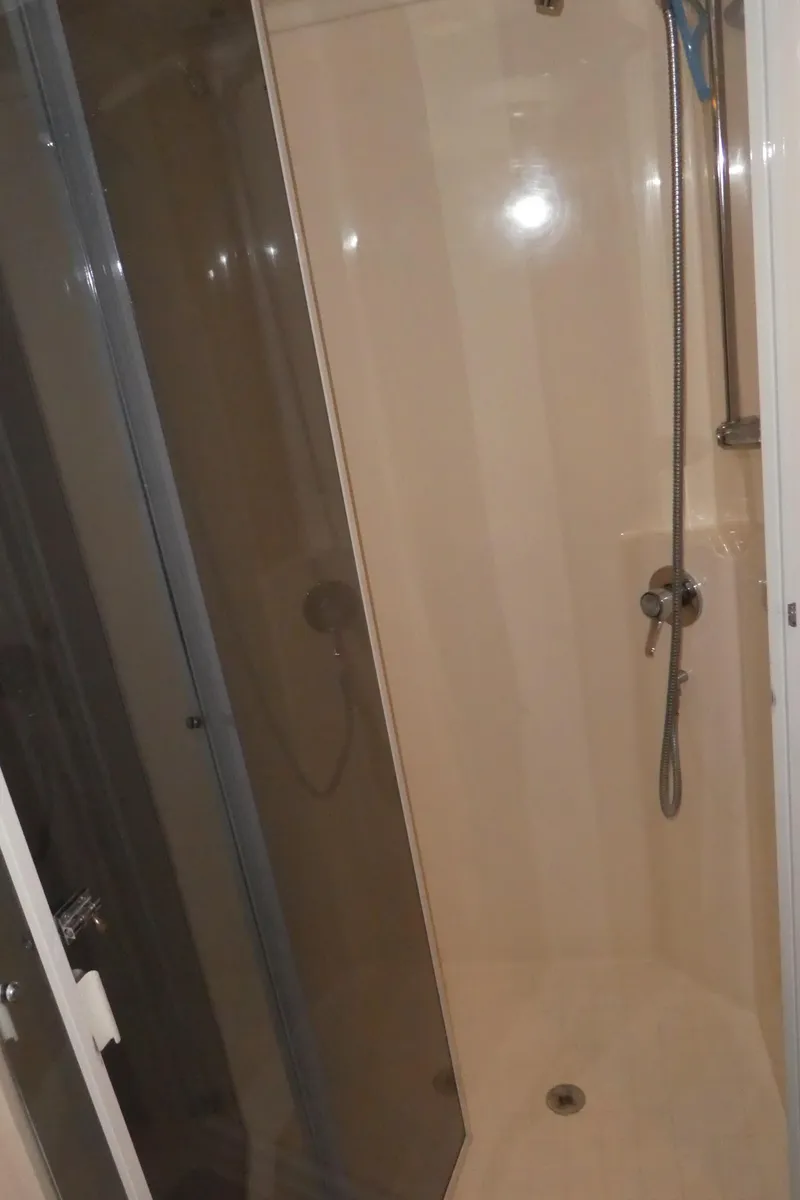 Slide: The Image of Shower area inside a 1995 Riviera Convertible boat, featuring a handheld showerhead. - 16