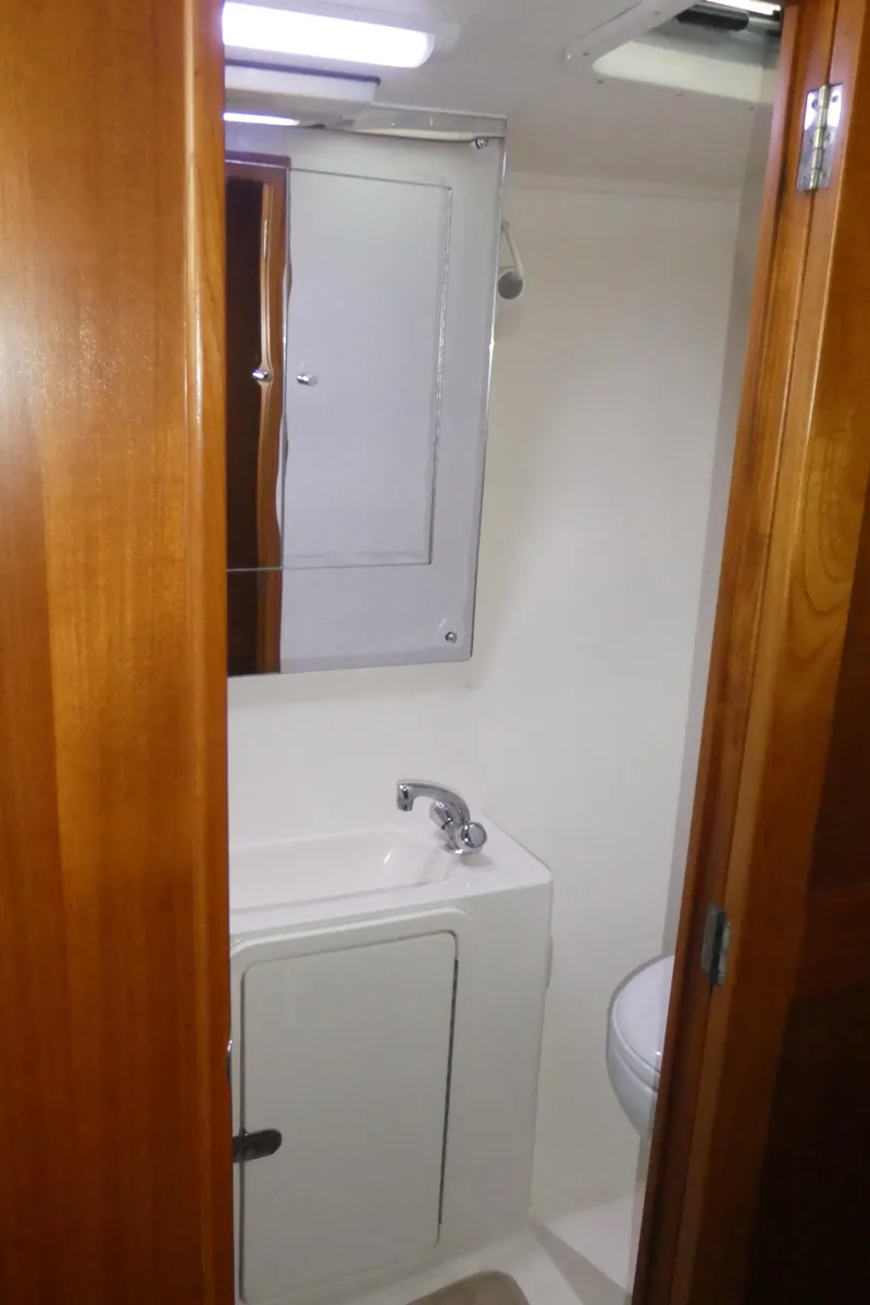 Slide: The Image of 1995 Riviera Convertible bathroom with wooden door, sink, and mirror. - 21