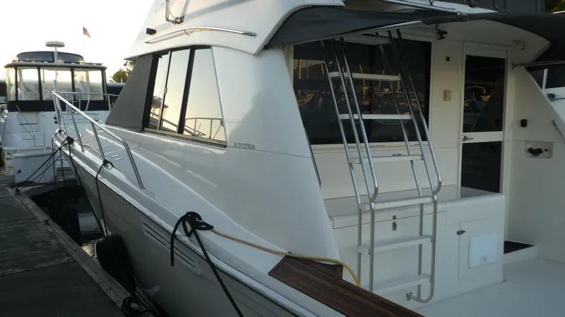 Slide: The Image of 1995 Riviera Convertible yacht docked, featuring sleek design and ladder access. - 22