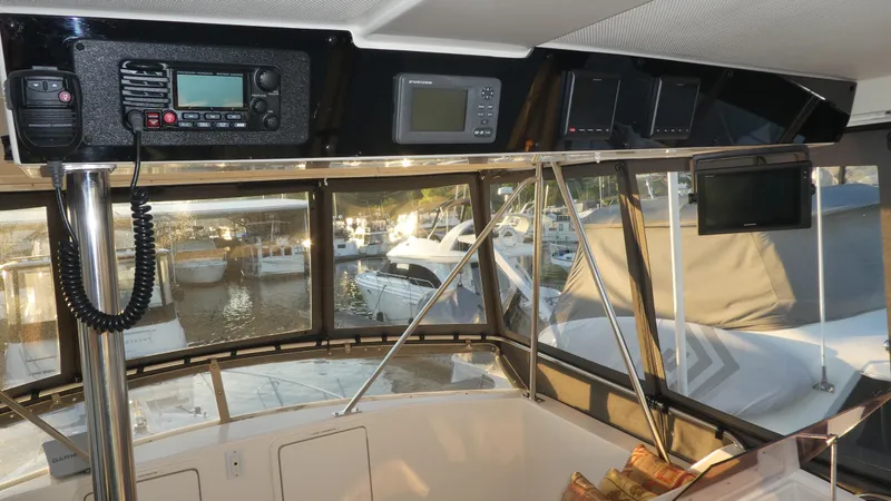 Slide: The Image of Interior view of a 1995 Riviera Convertible boat with navigation equipment and marina background. - 25