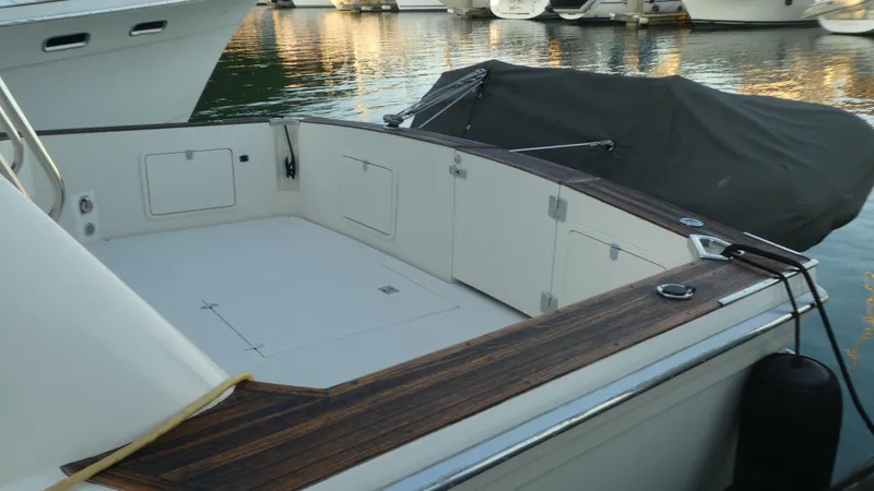 Slide: The Image of 1995 Riviera Convertible boat deck with wooden trim, docked at marina. - 44
