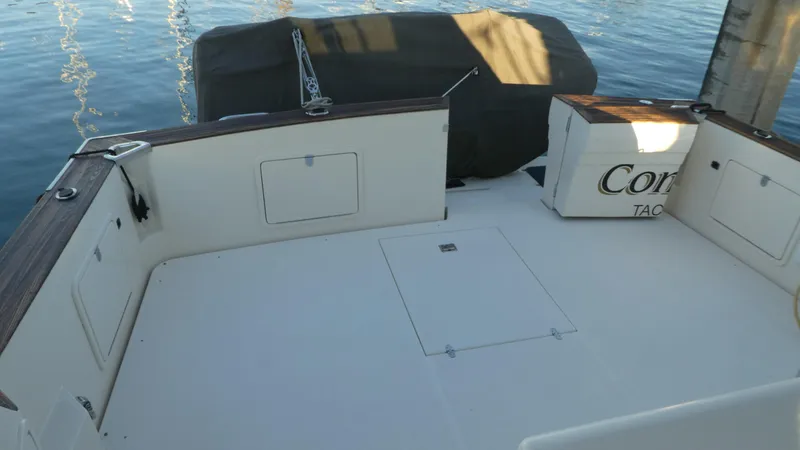 Slide: The Image of 1995 Riviera Convertible boat deck with storage compartments, docked by calm water. - 48