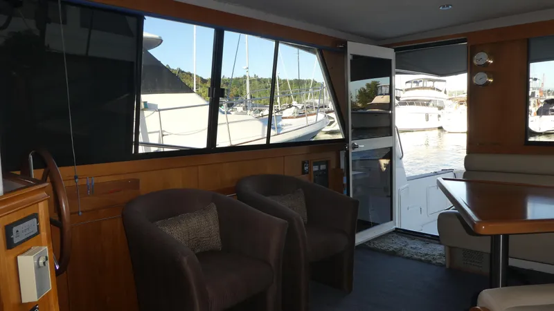 Slide: The Image of Interior of 1995 Riviera Convertible yacht with chairs, table, and marina view. - 5