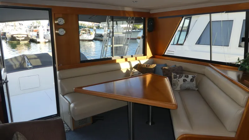 Slide: The Image of Interior of a 1995 Riviera Convertible yacht with a cozy dining area and marina view. - 6