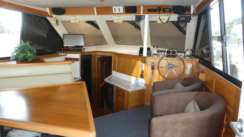 Slide: The Image of 1995 Riviera Convertible yacht interior with helm, seating, and wooden cabinetry. - 7