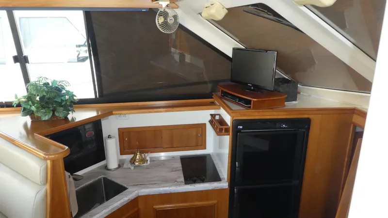 Slide: The Image of Interior of 1995 Riviera Convertible yacht with kitchenette, TV, and modern amenities. - 8