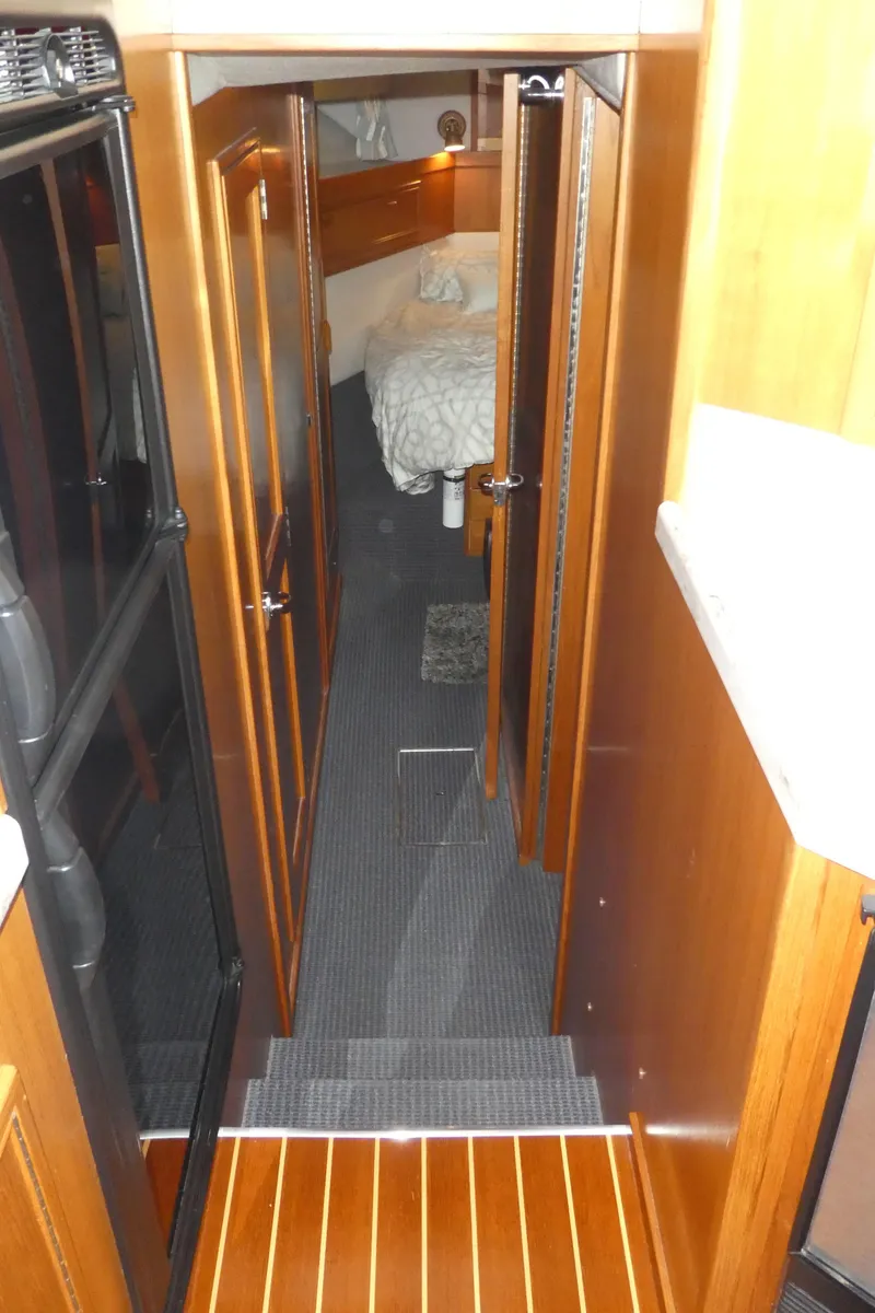Slide: The Image of Interior of 1995 Riviera Convertible yacht, featuring a cozy cabin with wooden finishes. - 9