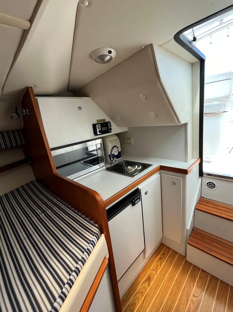 Slide: The Image of 2005 Tiara Yachts 2900 Coronet interior with kitchenette and striped seating. - 17