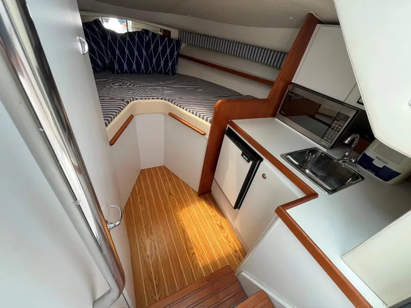 Slide: The Image of 2005 Tiara Yachts 2900 Coronet interior with kitchenette, bed, and wood flooring. - 18