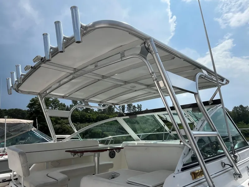 Slide: The Image of 2005 Tiara Yachts 2900 Coronet with sleek canopy and seating, docked under a clear sky. - 6