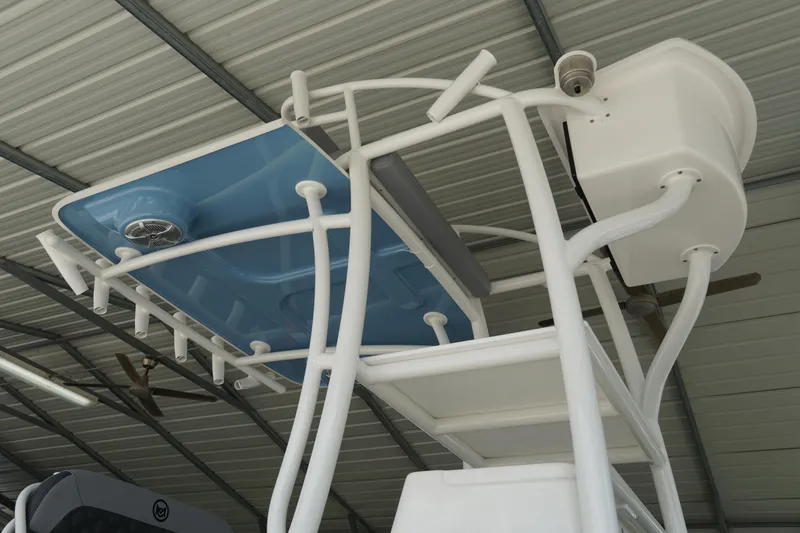 Slide: The Image of 2026 May-Craft 238 Center Console T-top with rod holders and speakers in a covered storage area. - 10