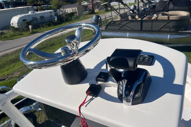 Slide: The Image of Steering console of 2026 May-Craft 238 Center Console boat with controls and keys. - 13