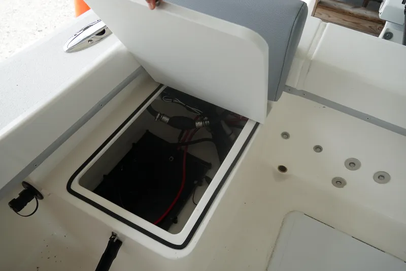 Slide: The Image of 2026 May-Craft 238 Center Console storage compartment with open lid, revealing interior components. - 20