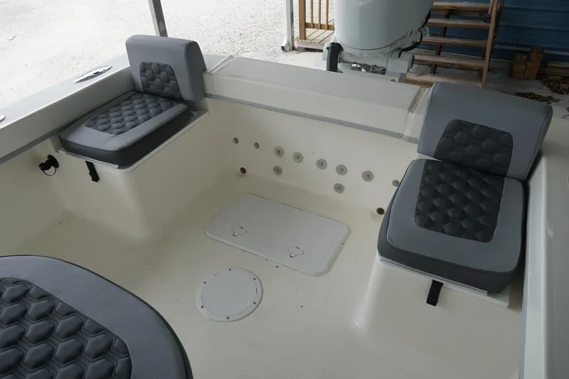 Slide: The Image of 2026 May-Craft 238 Center Console boat interior with cushioned seating and storage compartments. - 25
