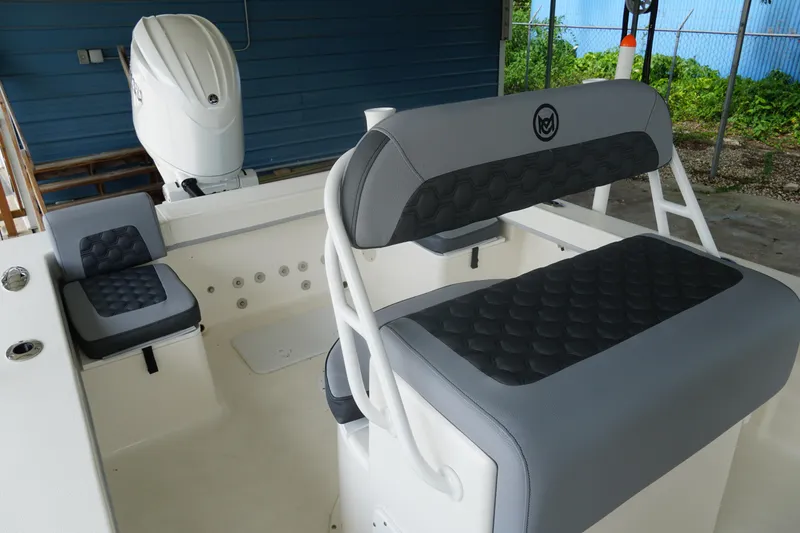 Slide: The Image of 2026 May-Craft 238 Center Console boat interior with cushioned seating and outboard motor. - 41