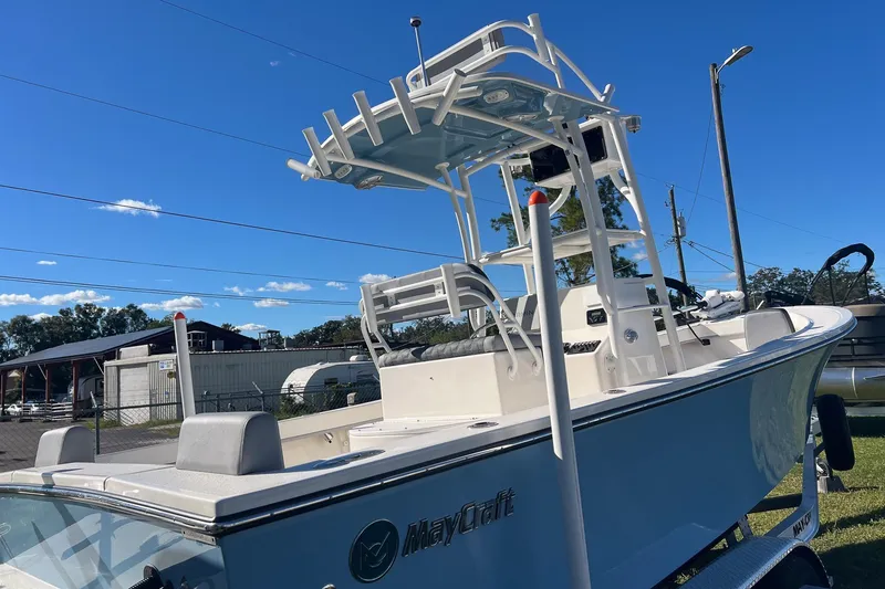 Slide: The Image of 2026 May-Craft 238 Center Console boat with T-top, parked outdoors under clear blue sky. - 6