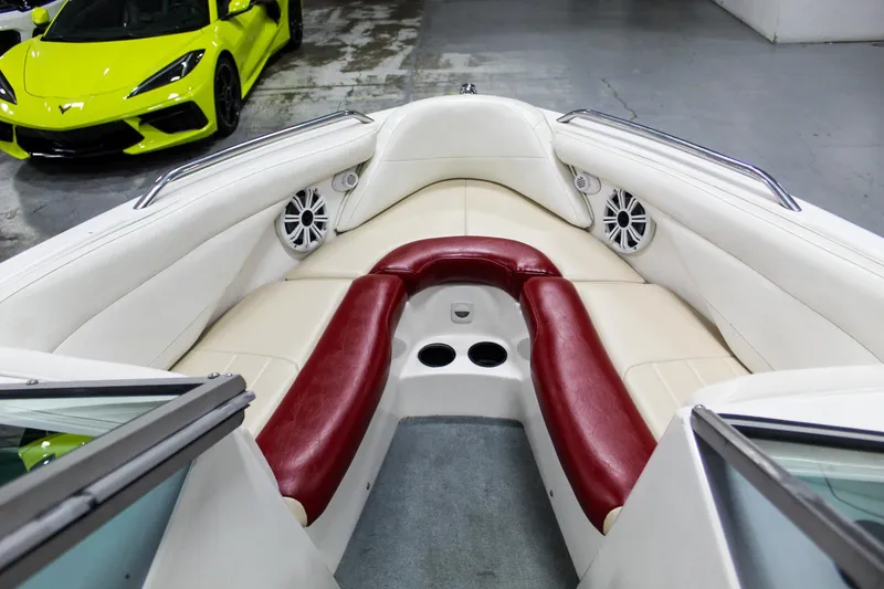 Slide: The Image of 2002 MasterCraft X-10 boat interior with red and white seating, parked near a yellow sports car. - 10