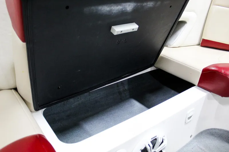 Slide: The Image of Open storage compartment in 2002 MasterCraft X-10 boat with red and white seating. - 27