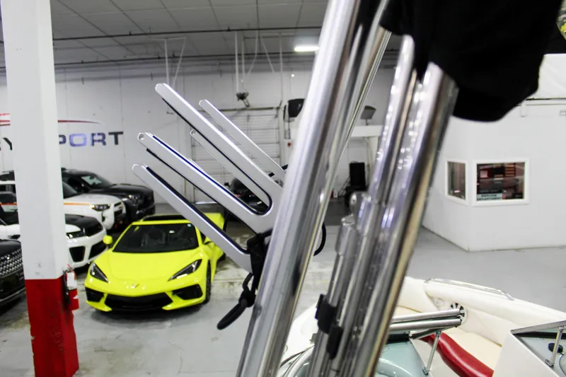 Slide: The Image of 2002 MasterCraft X-10 boat with chrome wakeboard rack in showroom, yellow sports car in background. - 32