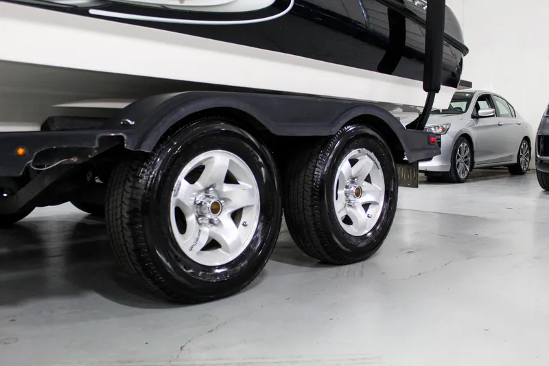 Slide: The Image of 2002 MasterCraft X-10 boat trailer with shiny wheels in a garage setting. - 39