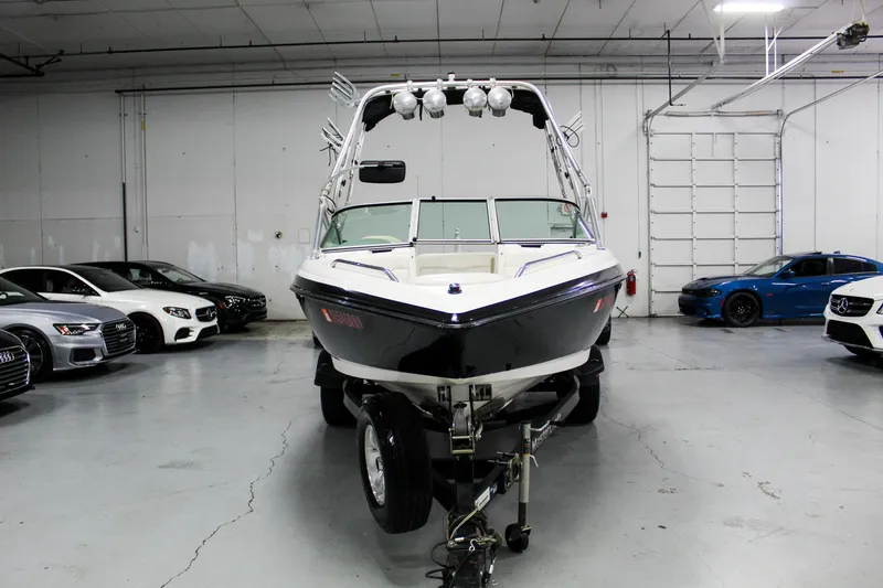 Slide: The Image of 2002 MasterCraft X-10 boat on trailer in a garage with cars. - 9