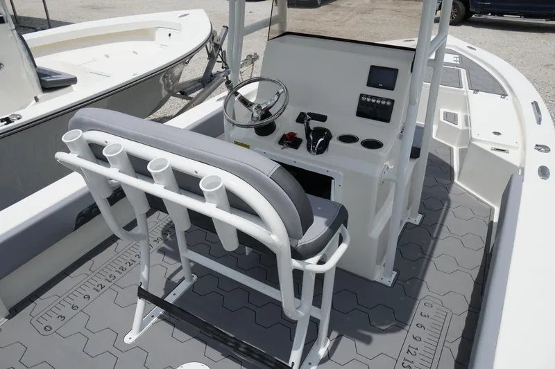 Slide: The Image of 2026 May-Craft 220 Bay boat interior with steering console and rod holders. - 2