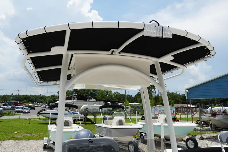 Slide: The Image of 2026 May-Craft 220 Bay boat with T-top canopy in a dealership lot. - 23