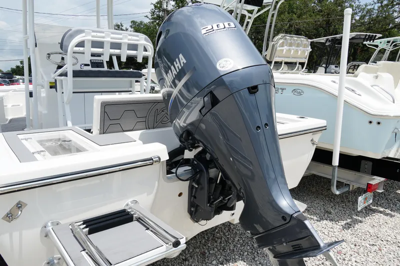 Slide: The Image of 2026 May-Craft 220 Bay boat with Yamaha 200 outboard motor, parked on gravel. - 34