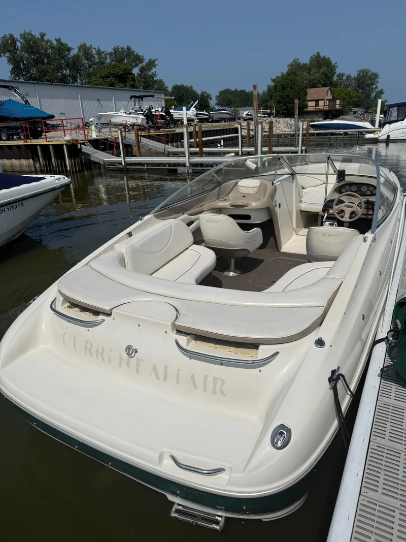Slide: The Image of 1999 Bayliner 2350 Capri SS boat docked, featuring spacious seating and sleek design. - 14