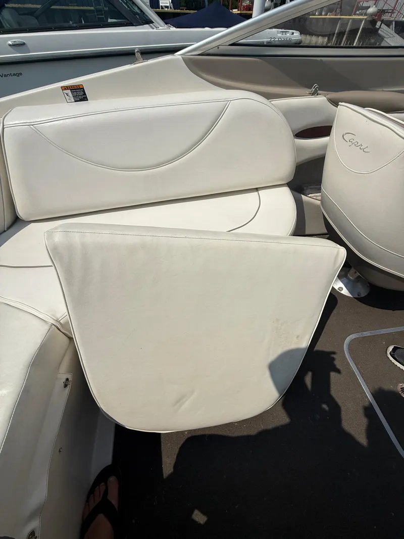 Slide: The Image of 1999 Bayliner 2350 Capri SS boat interior with white cushioned seating. - 2