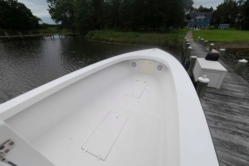 Slide: The Image of 2023 Rambo 27 Center Console boat docked by a serene lakeside. - 10