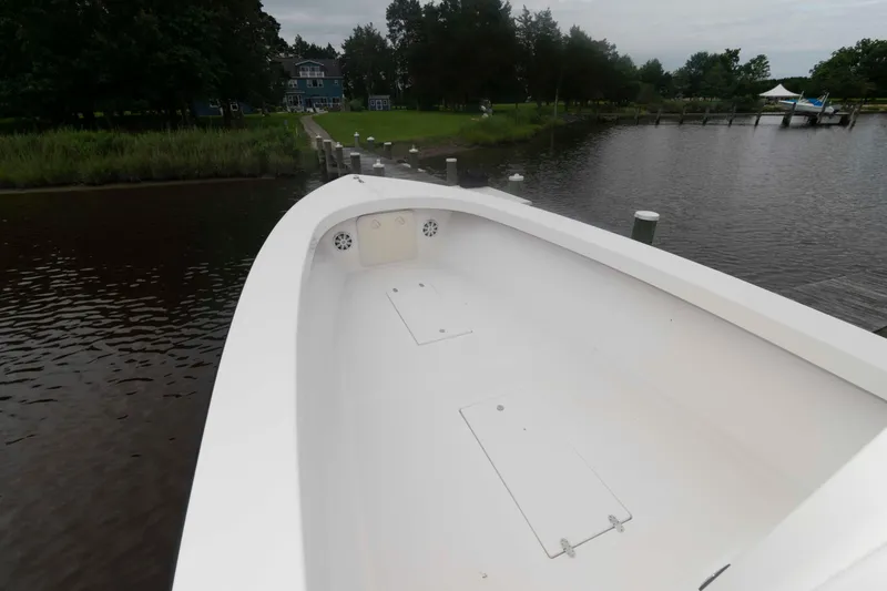 Slide: The Image of 2023 Rambo 27 Center Console boat docked by a serene lakeside. - 11