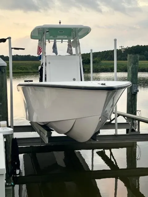 Slide: The Image of 2023 Rambo 27 Center Console boat docked on a lift at sunset. - 2