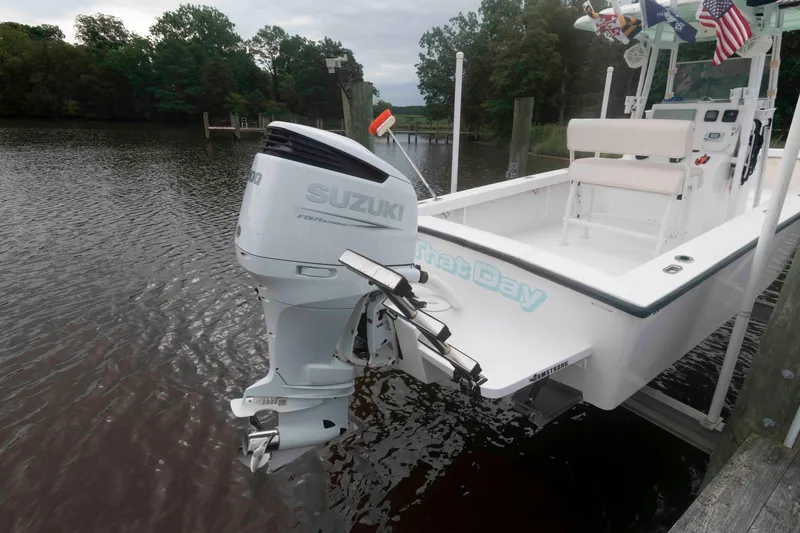 Slide: The Image of 2023 Rambo 27 Center Console boat with Suzuki outboard motor docked on a calm river. - 4