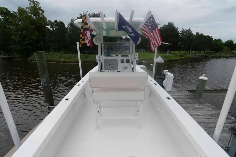Slide: The Image of 2023 Rambo 27 Center Console boat docked, featuring flags and serene waterway backdrop. - 5